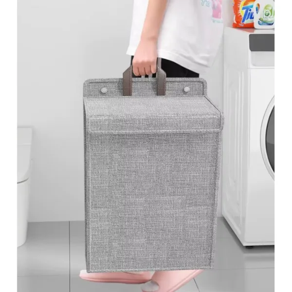 Coș de rufe pliabil gri cu mâner lărgit ergonomic evidențiat pentru transport ușor.
