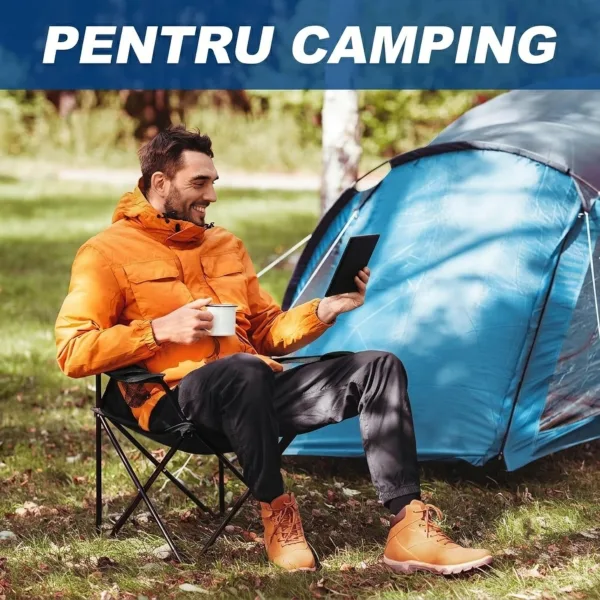 Persoană relaxată citind lângă cort pe un scaun de camping albastru ABYZ în mijlocul naturii.